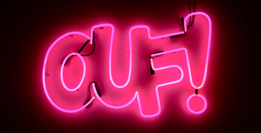 Neon pink sign of the word "OUF!"