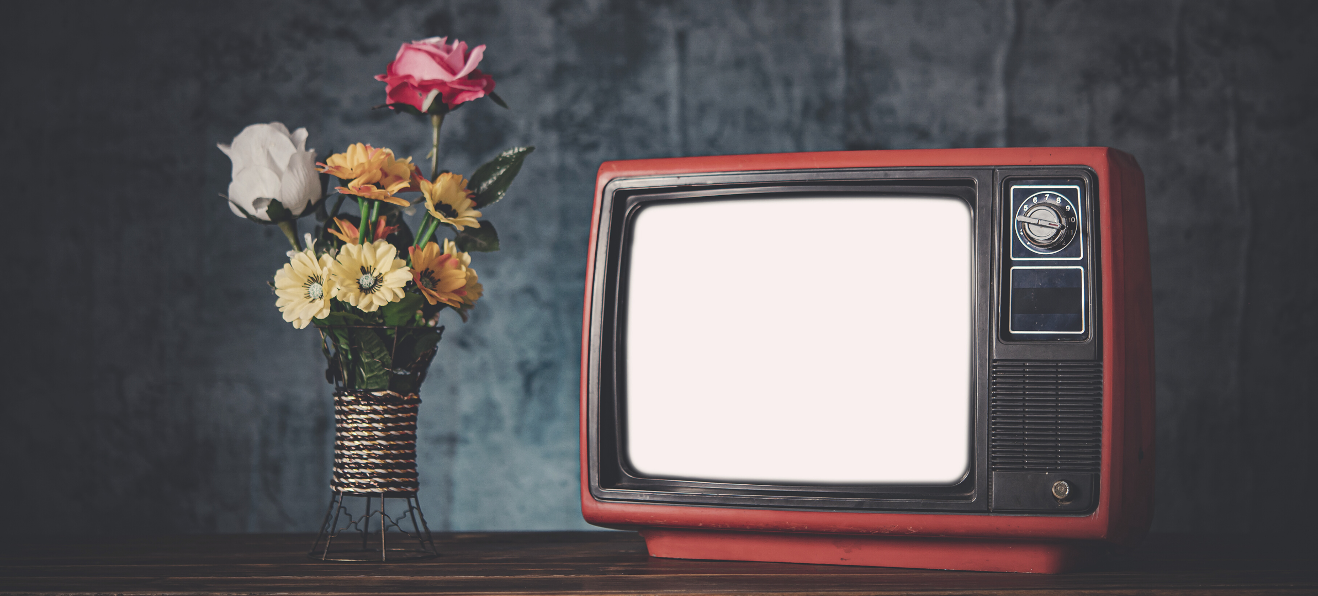 Photo of antique TV next to a vase of flowers