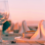 Table setting at a restaurant by the water at sunset