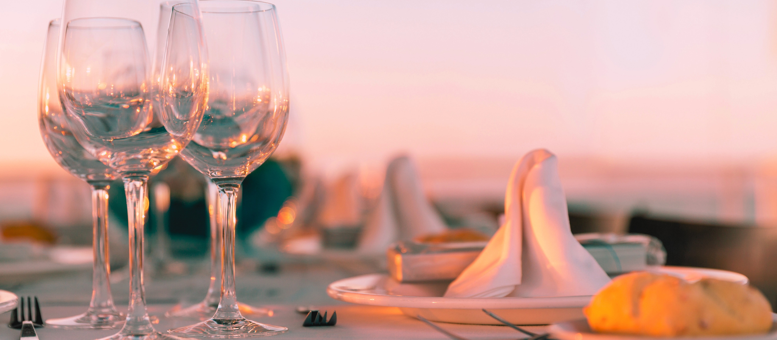 Table setting at a restaurant by the water at sunset