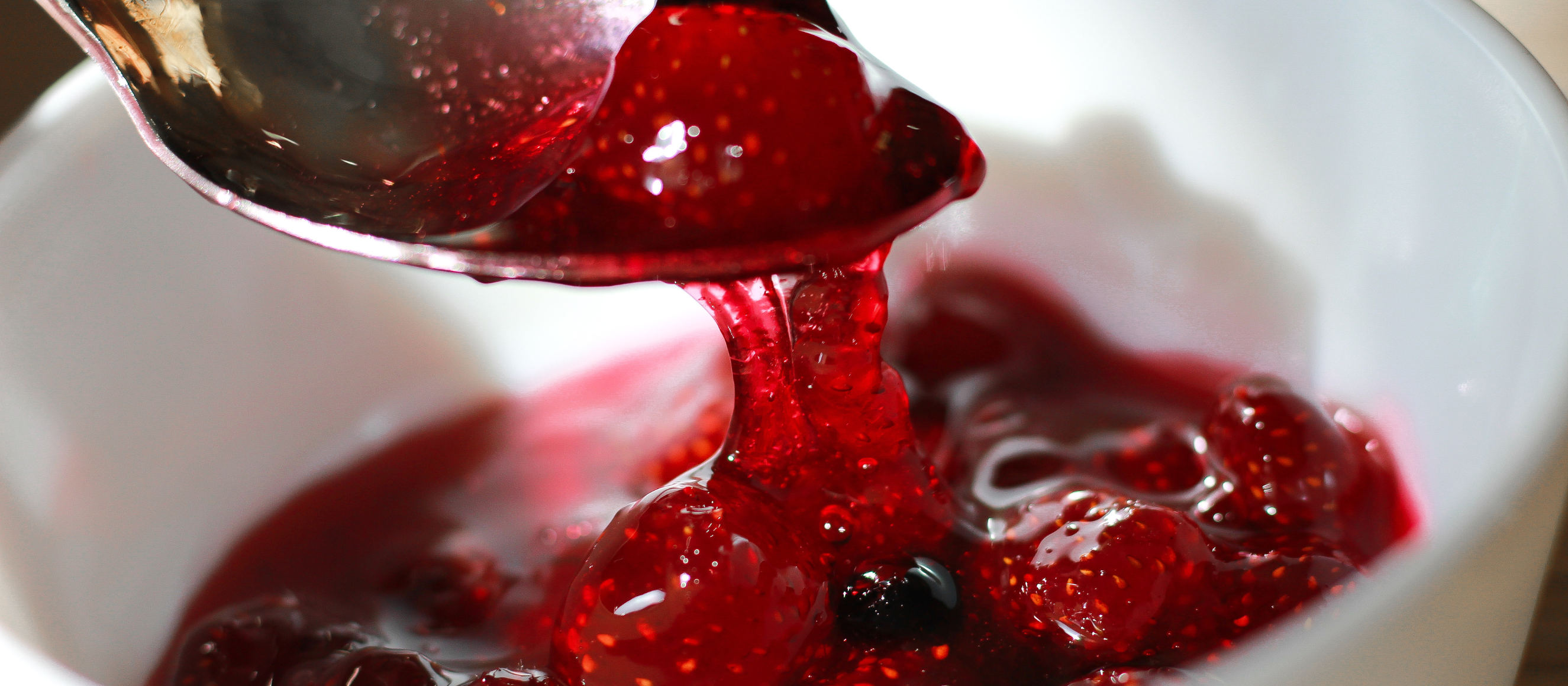 Photo of a spoon covered in strawberry jam