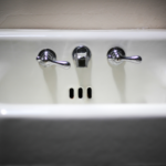 Photo of an old bathroom sink surrounded by darkness