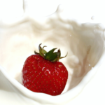 Photo of a strawberry dropping into milk