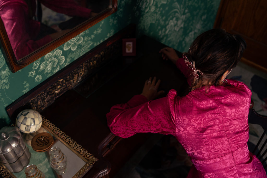 Photo by Foxspit of a woman leaning over a desk with her face away from the camera